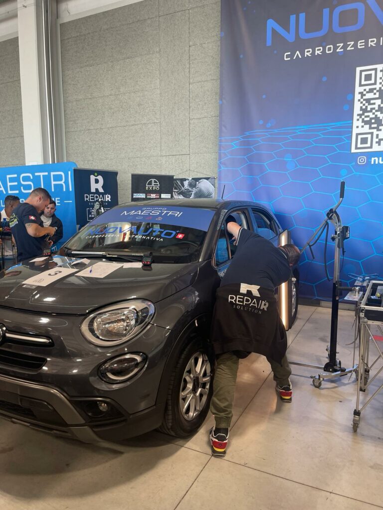 Tecnico Repair Solution durante riparazione ammaccature auto con tecnica PDR